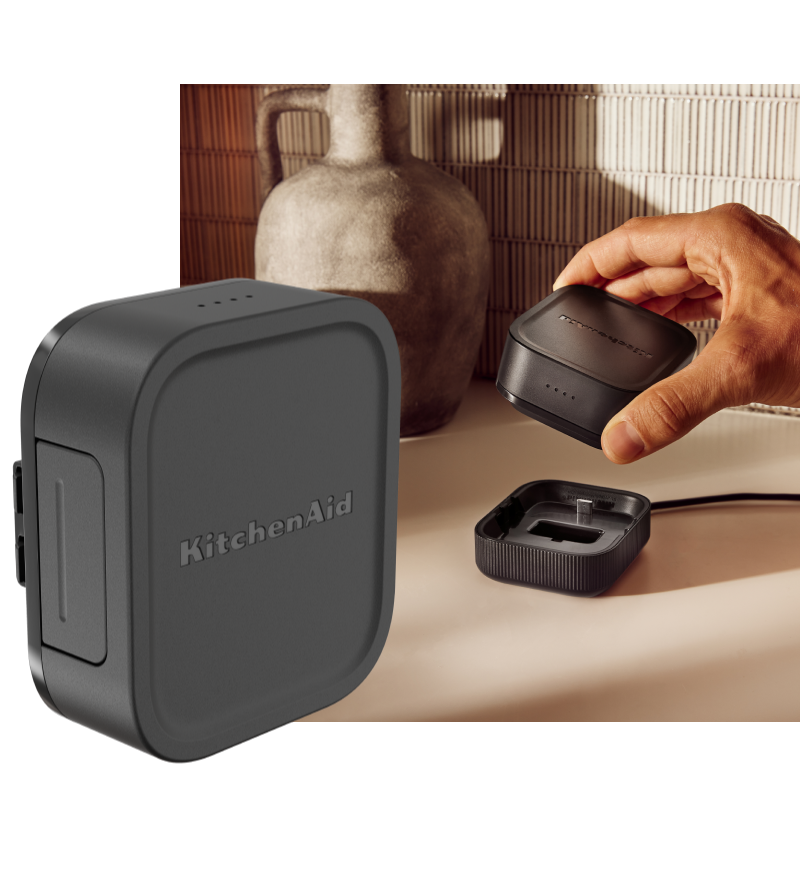 KitchenAid Go™ 12V Max Lithium Ion Rechargeable Battery and a person placing the battery on the charging dock.