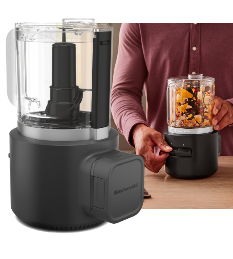   KitchenAid Go™ Cordless Chopper and a person using the chopper to chop orange, purple and yellow vegetables.