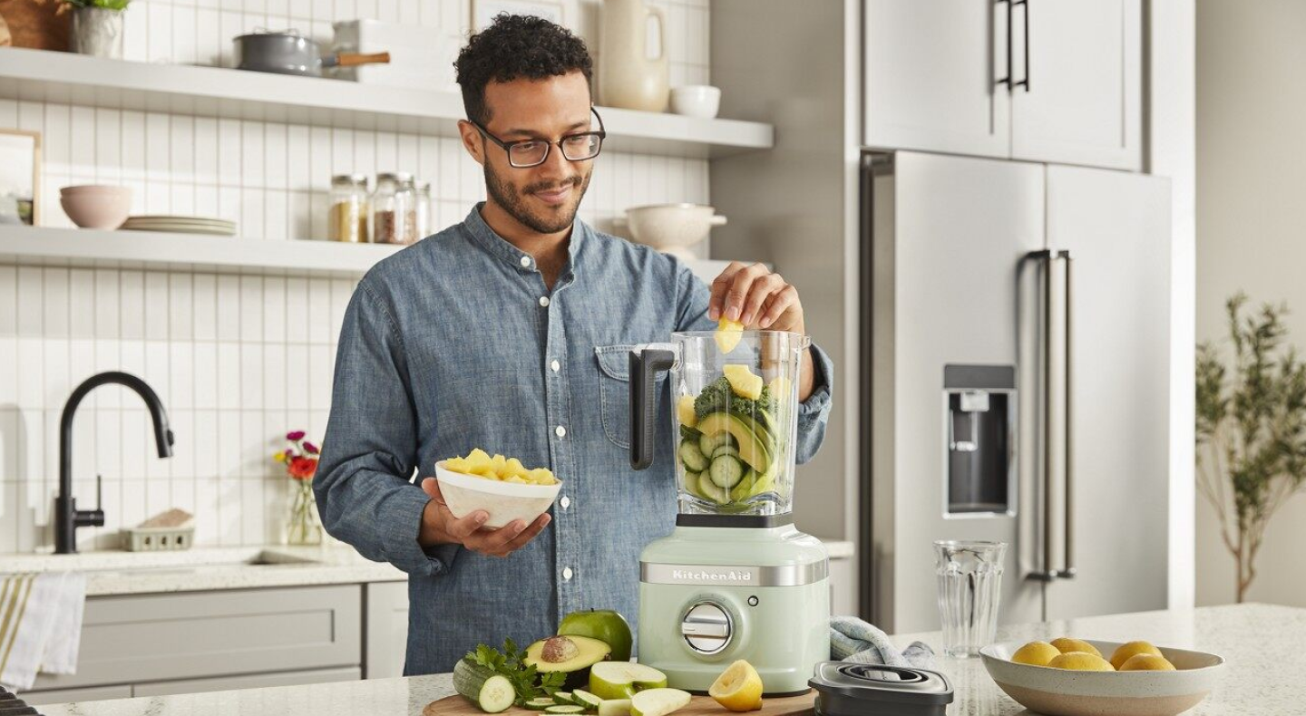 Person putting ingredients into KitchenAid® countertop blender 