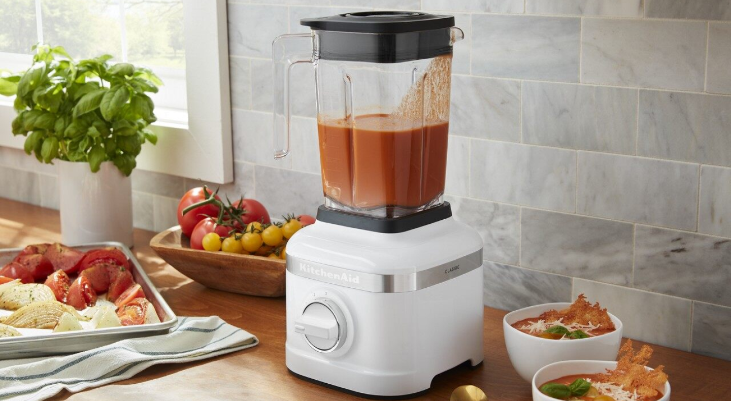White KitchenAid® countertop blender filled with orange soup