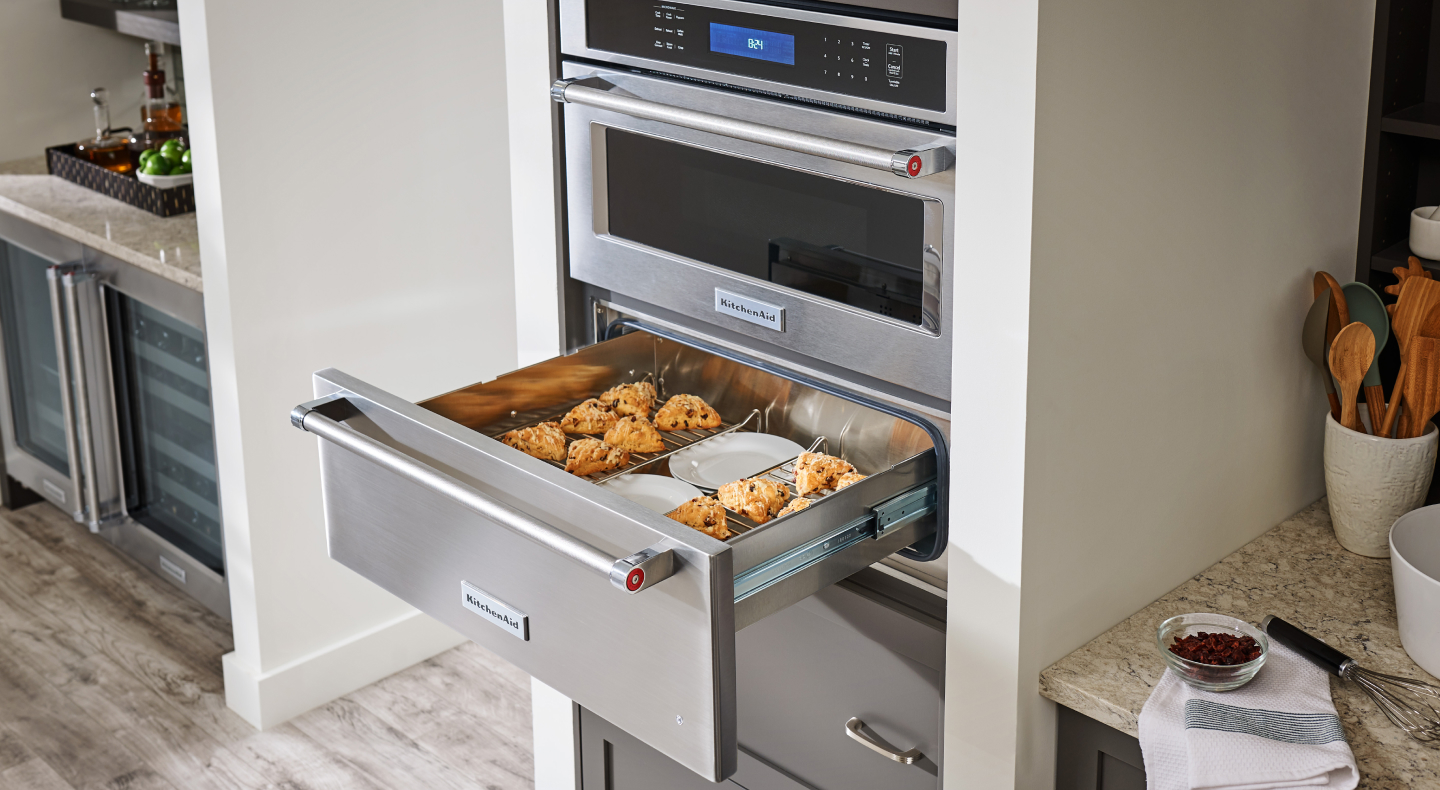 Baked goods and plates in open warming drawer
