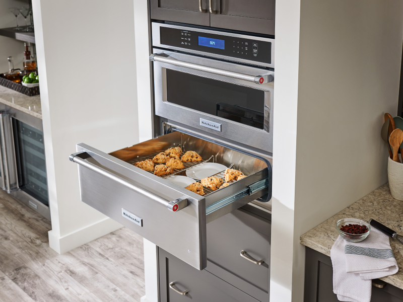 Baked goods and plates in open warming drawer