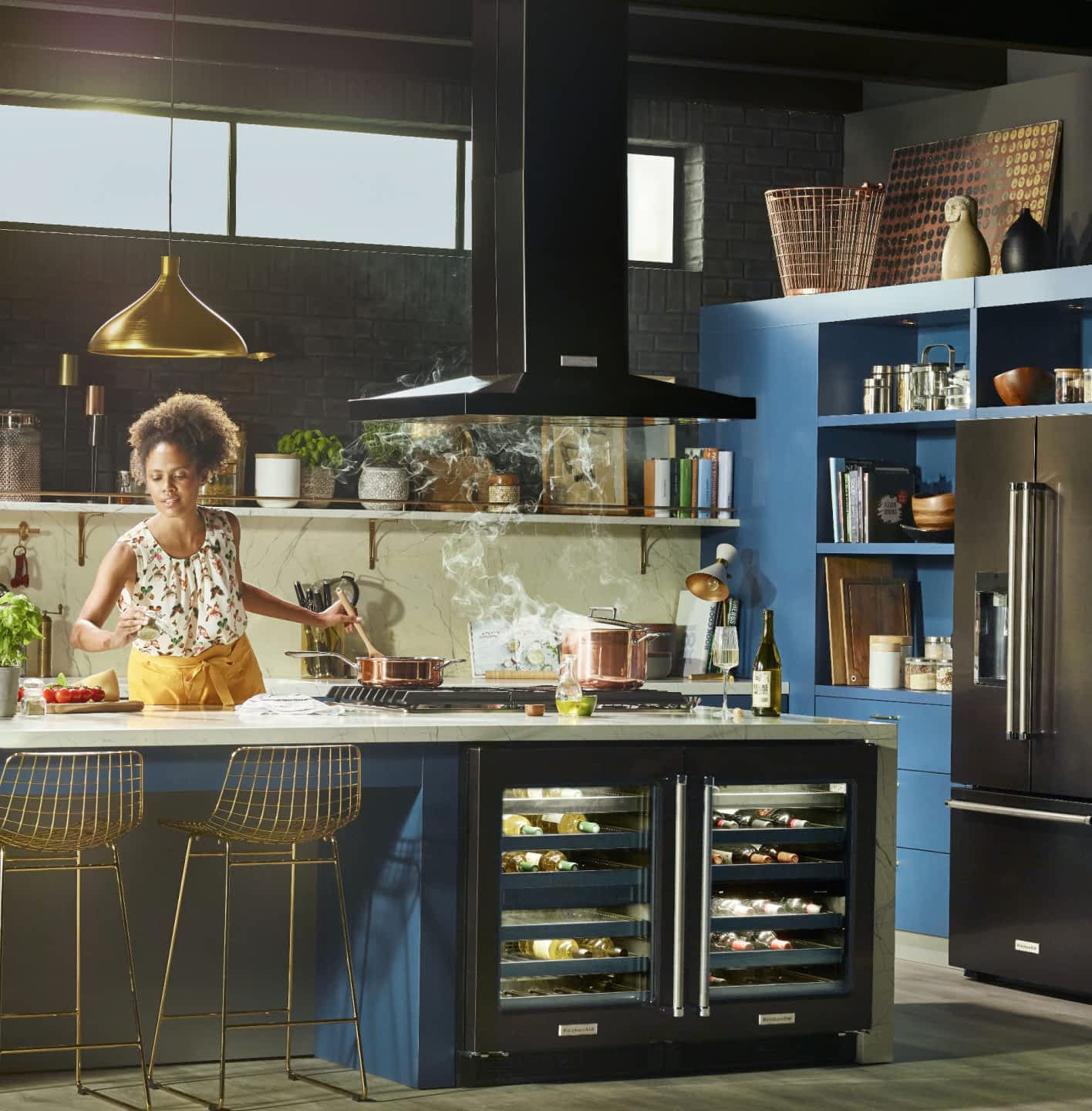 Young female Maker in a stylish, updated kitchen cooking over a pot of steaming liquid.