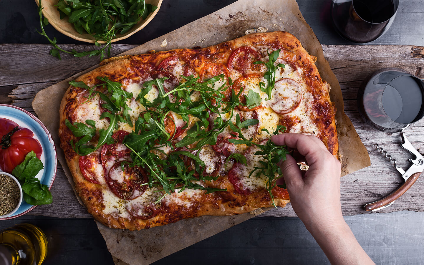 A freshly made flatbread pepperoni pizza sprinkled with arugula.