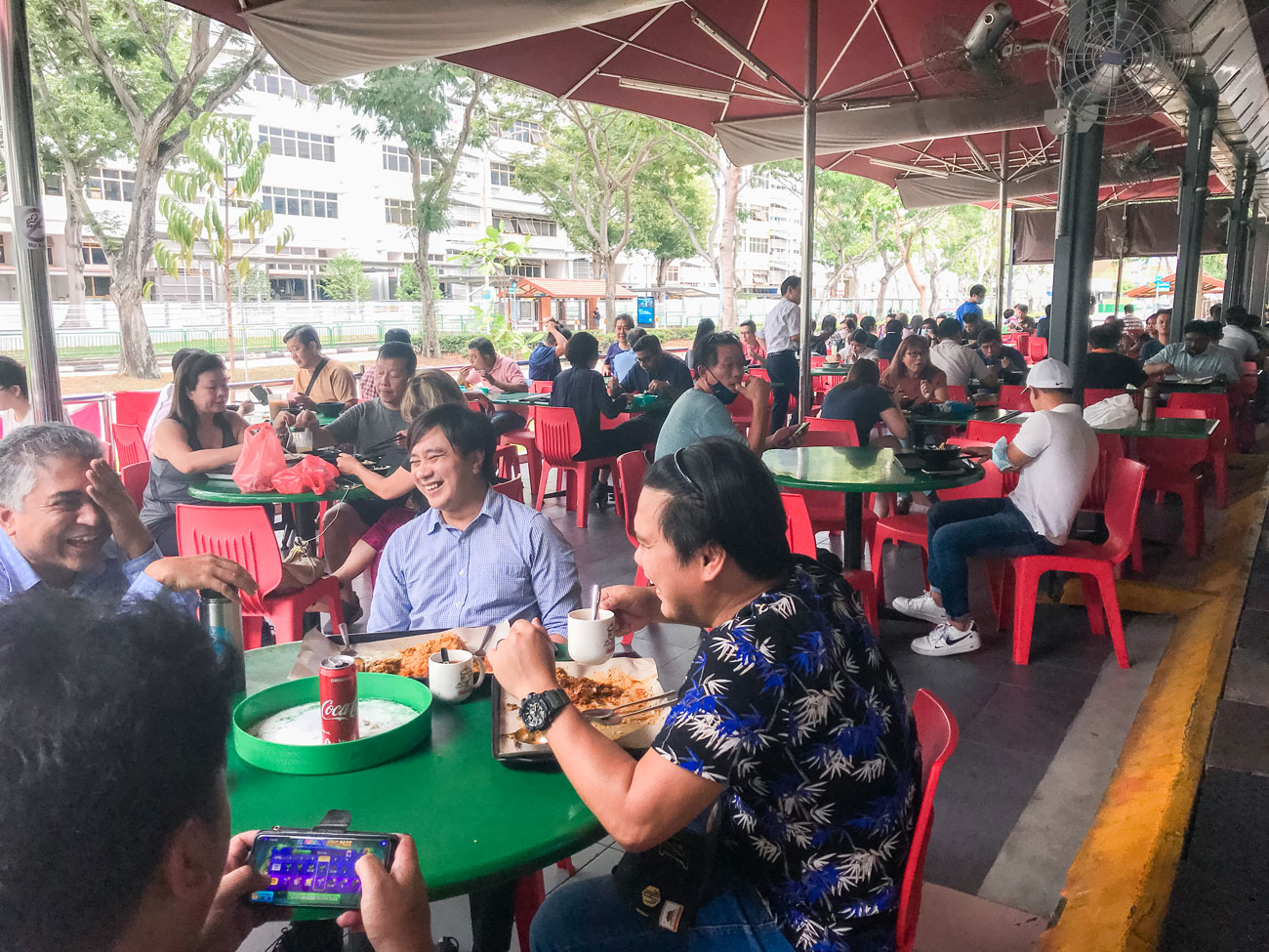 People sitting down enjoying their meals outside.
