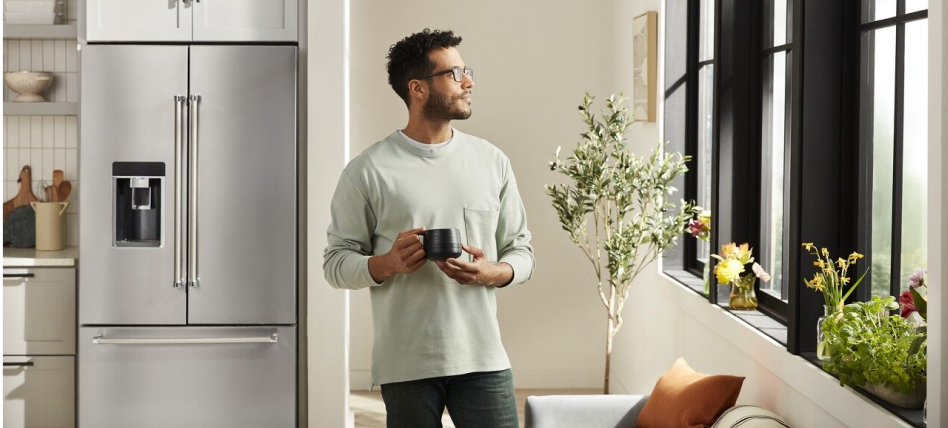 Person looking out the window from a kitchen with a stainless steel French door refrigerator