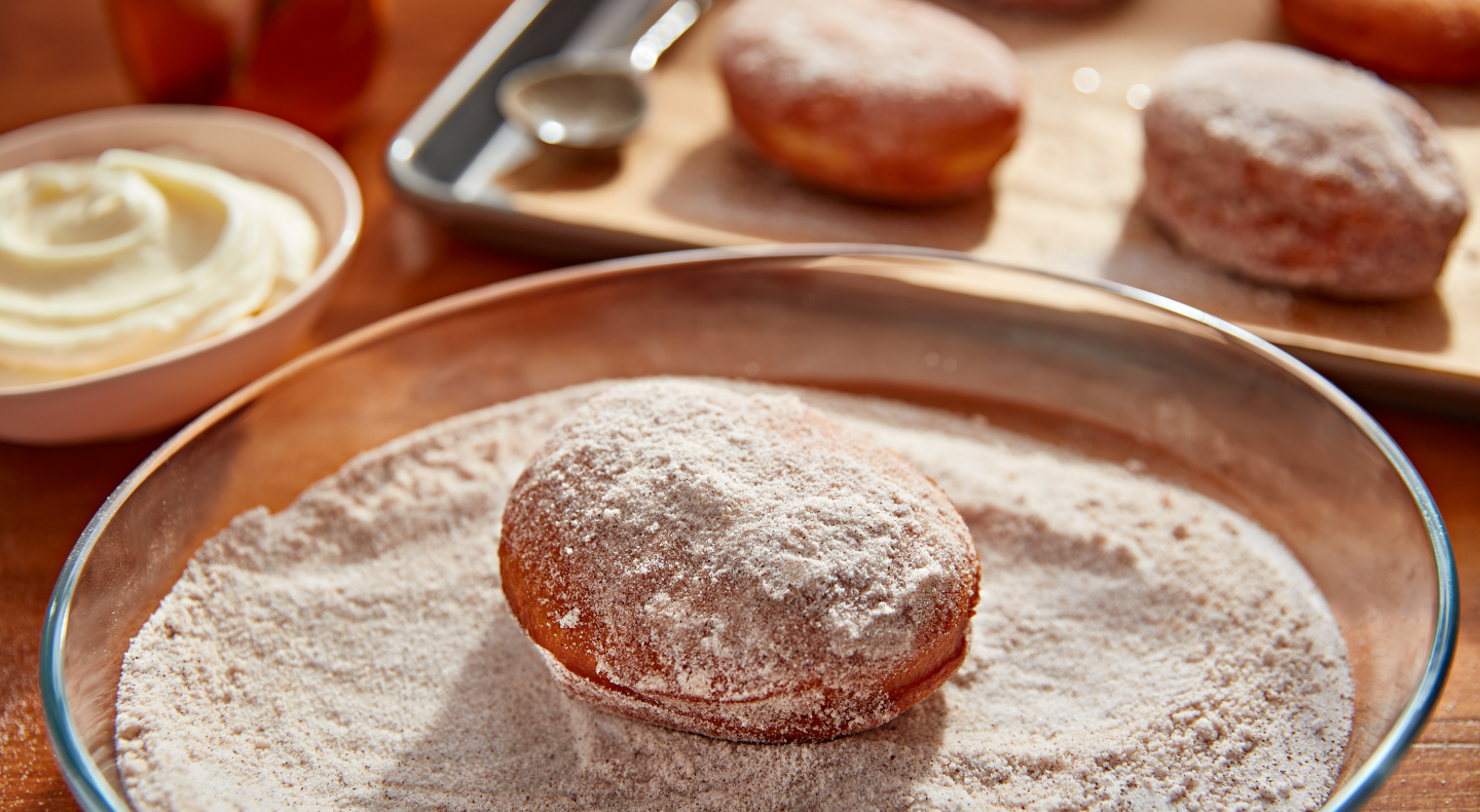 Donut in a bowl of light and dark brown sugar