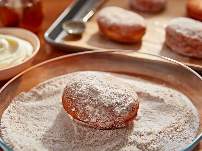 Donut in a bowl of light and dark brown sugar
