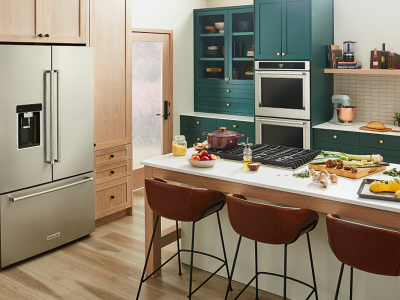 A trendy kitchen with teal cabinetry and a suite of KitchenAid® appliances