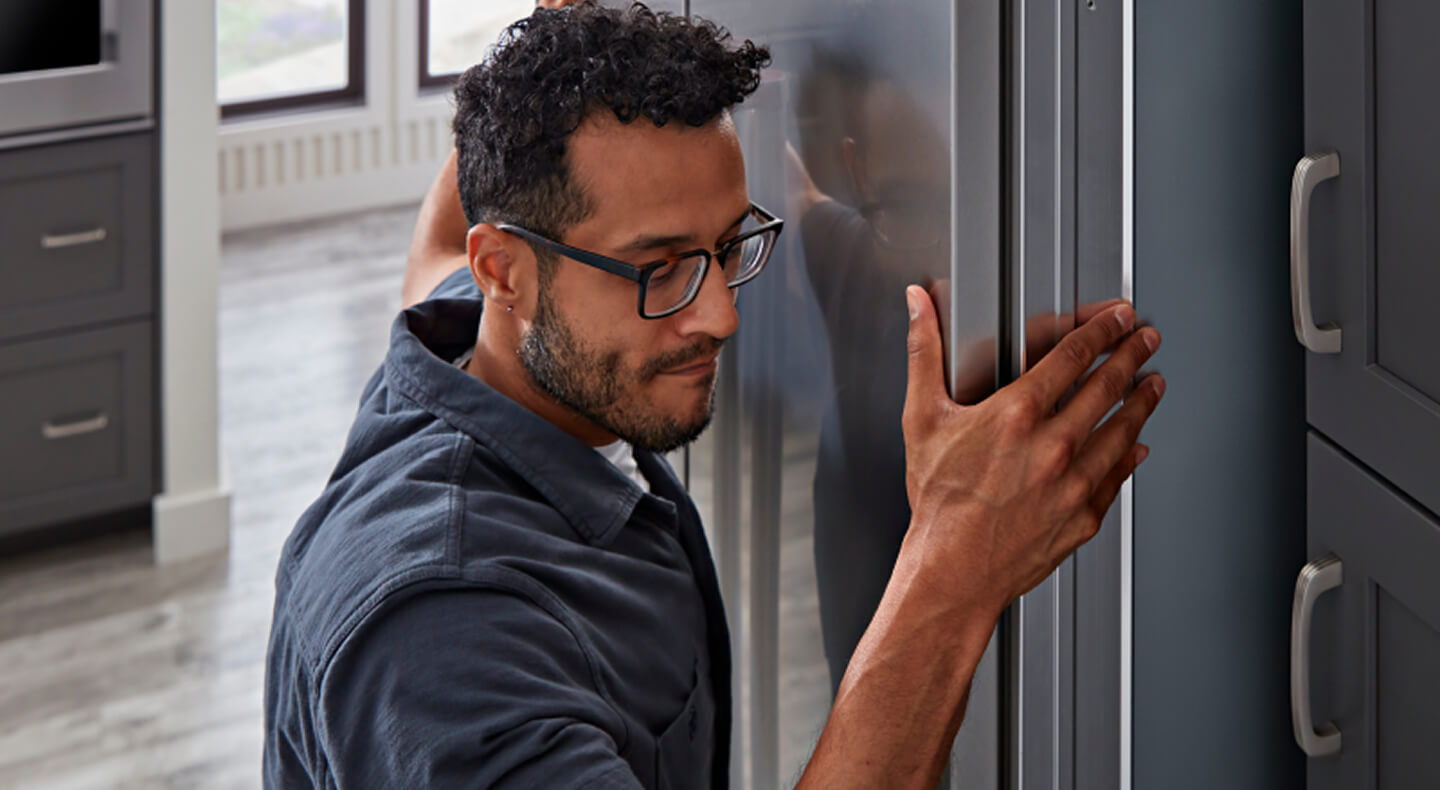 A man installing a KitchenAid® refrigerator