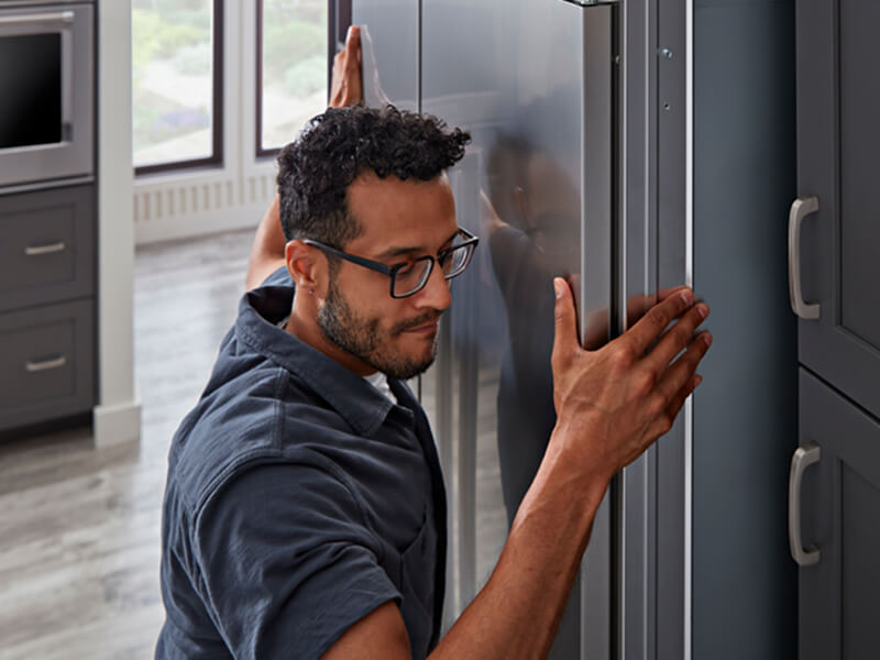 A man installing a KitchenAid® refrigerator