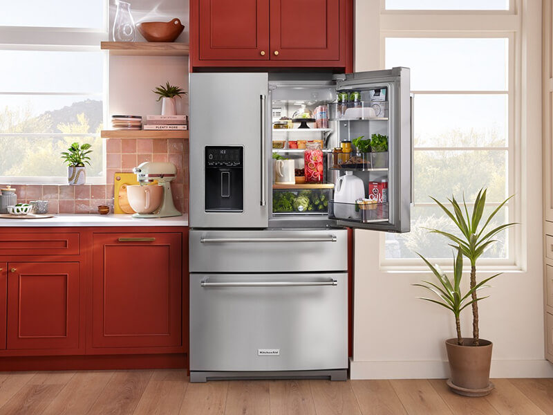 Open stainless steel KitchenAid® four door refrigerator with fresh food inside