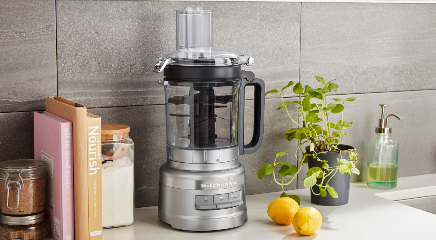 A KitchenAid® food processor on a modern kitchen counter.