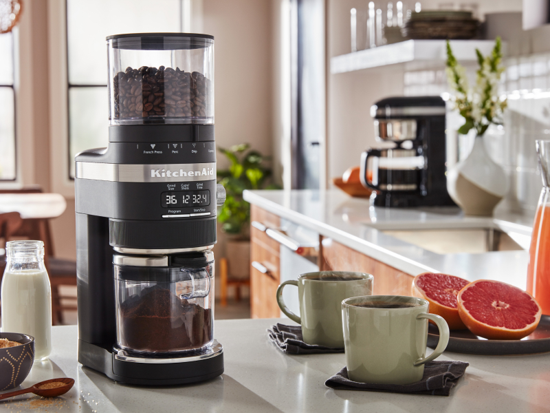 KitchenAid® burr grinder next to two coffee mugs