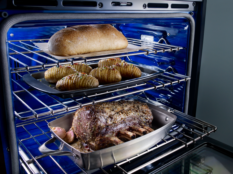 A rack with trays of baked goods and a loaf of bread