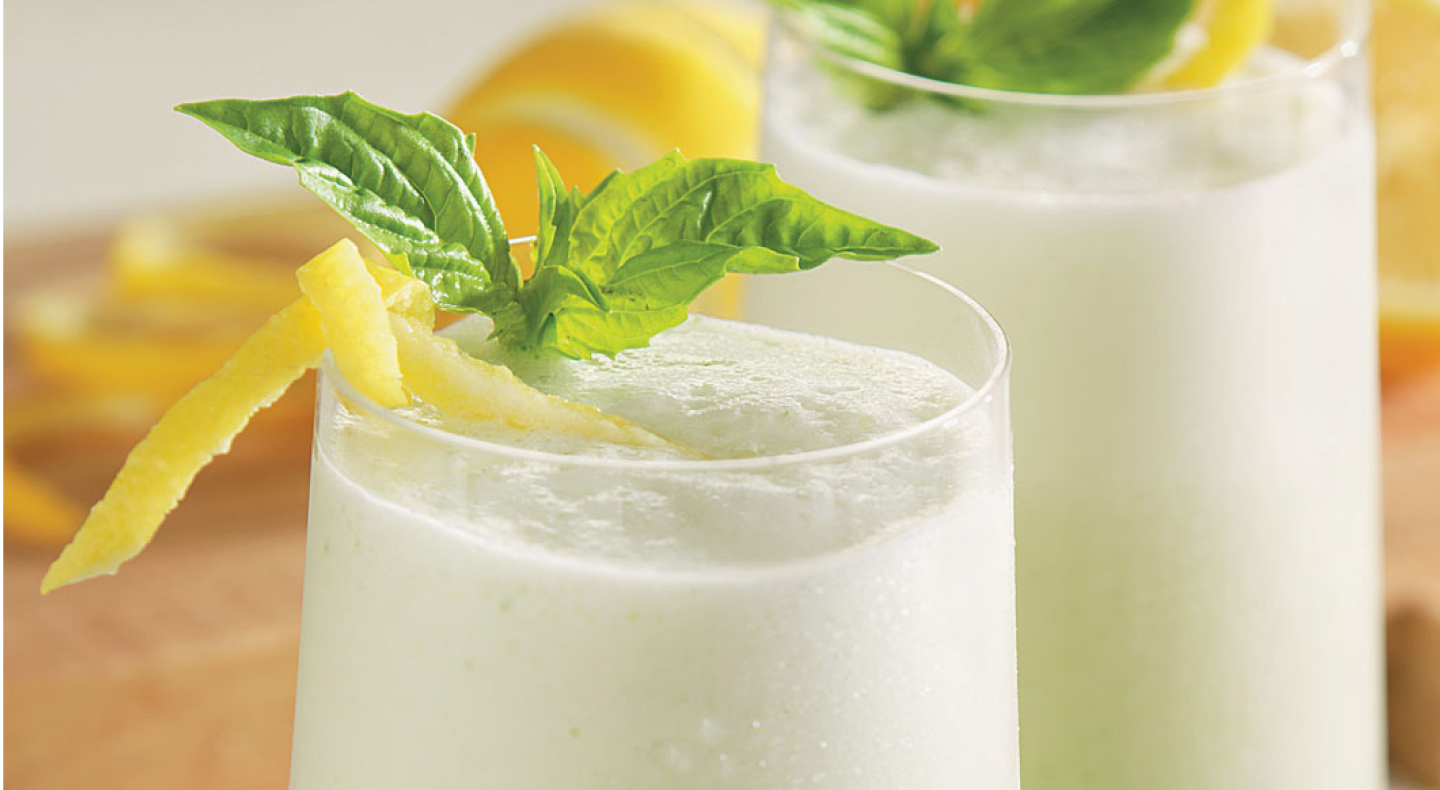 Margaritas with lemon peels and mint on top.
