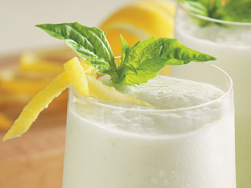 Margaritas with lemon peels and mint on top.