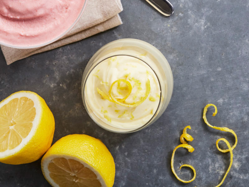 Parfait with lemon peels and whole lemons next to it.