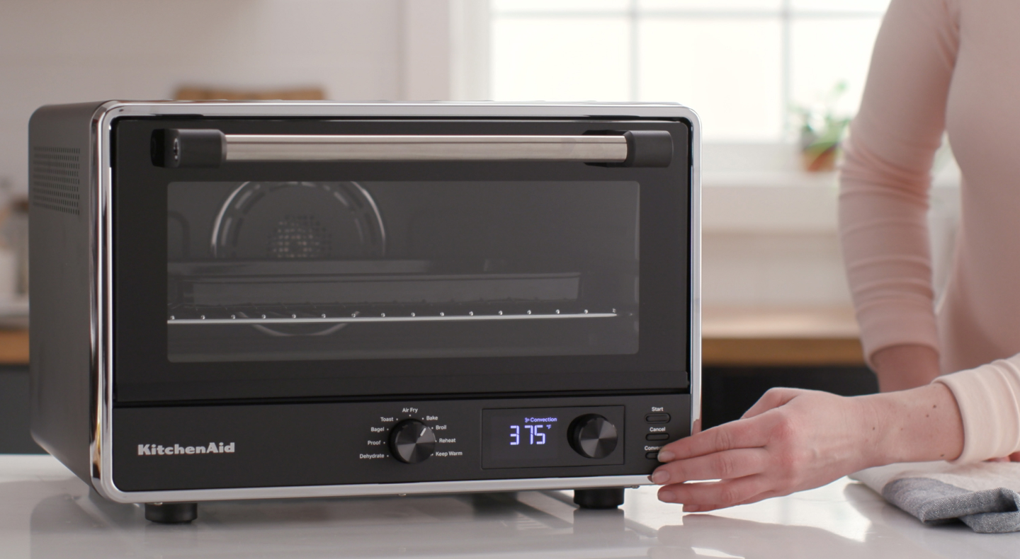 Person choosing a setting on a countertop oven