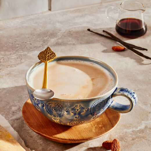 Latte in a ceramic mug with a stirring spoon