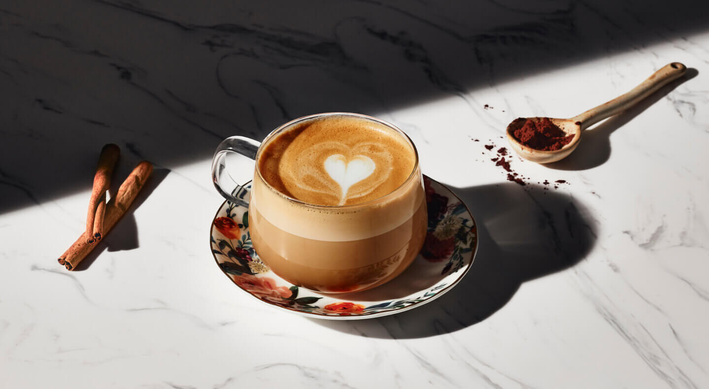 Latte with a steamed milk heart in a glass mug