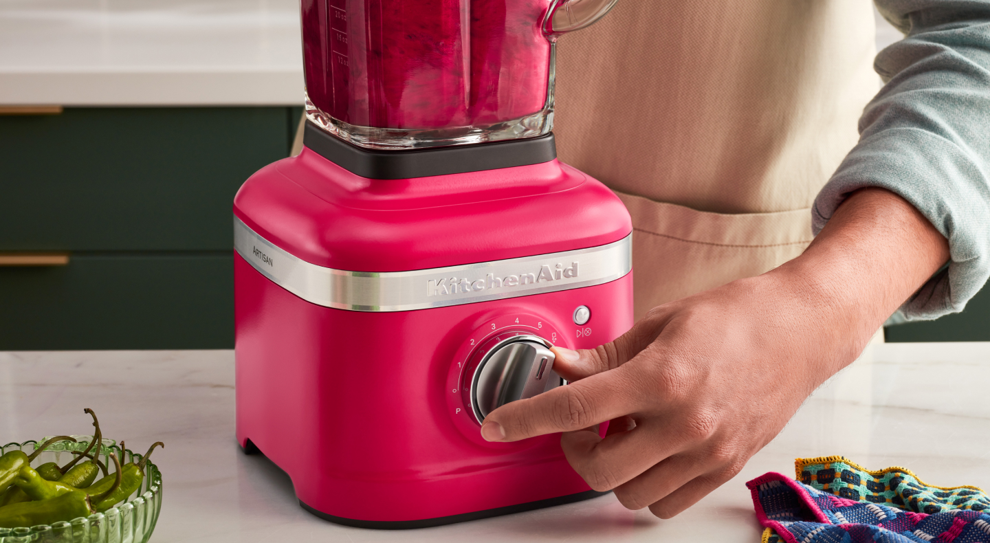 A person programming a blender setting on a KitchenAid® blender.
