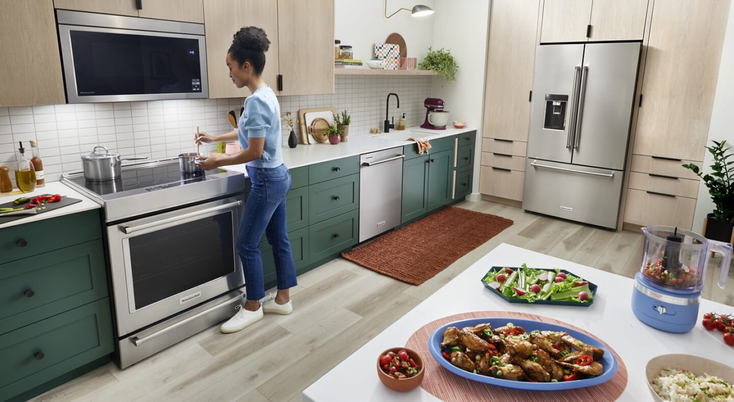 Person making chicken wings and an assortment of vegetables