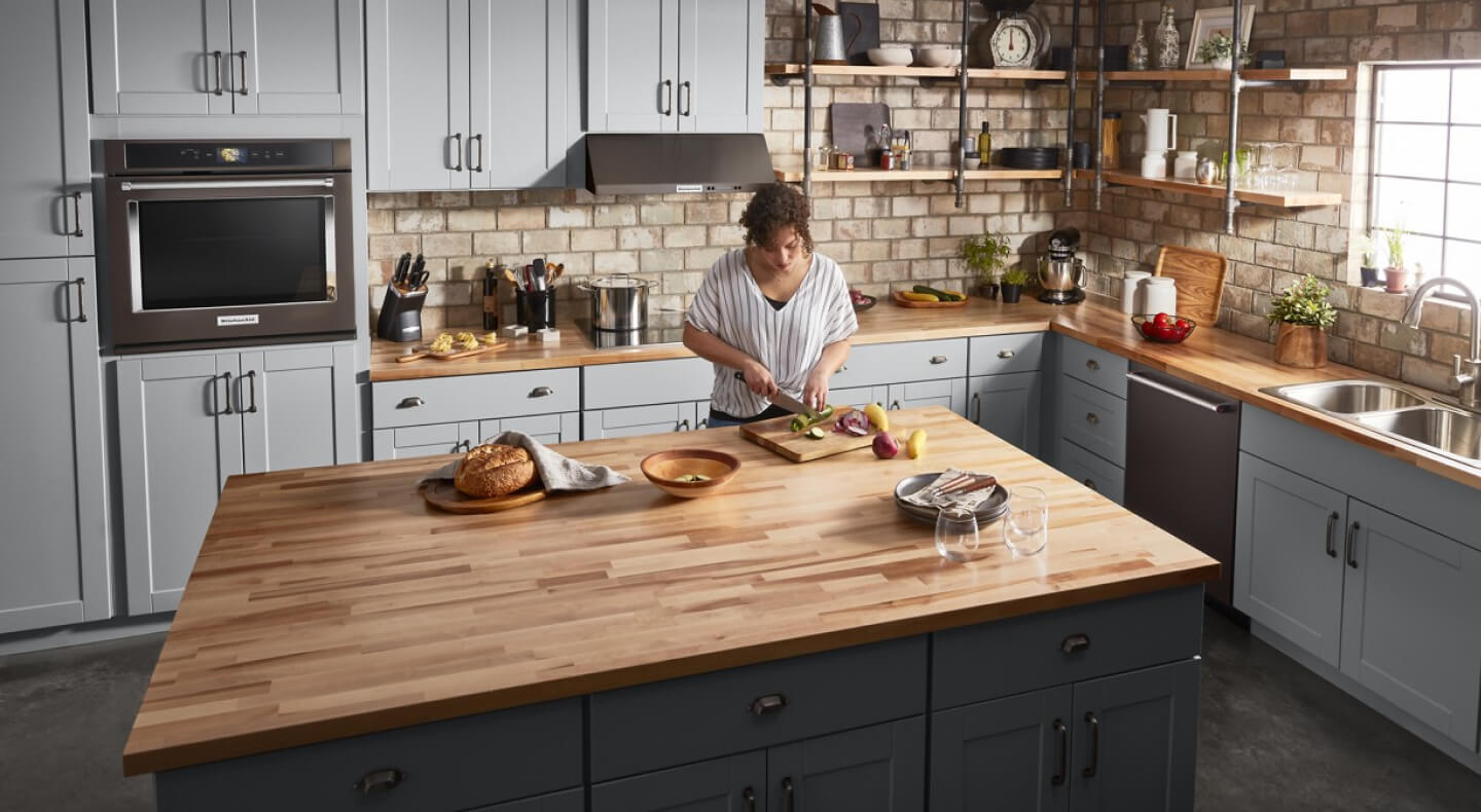Person cutting vegetables on a kitchen island