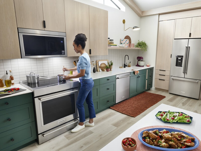 Person making chicken wings and an assortment of vegetables