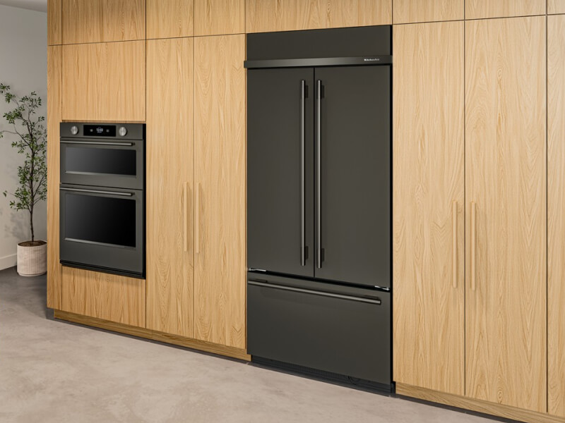 Black French door refrigerator and wall oven in an updated kitchen