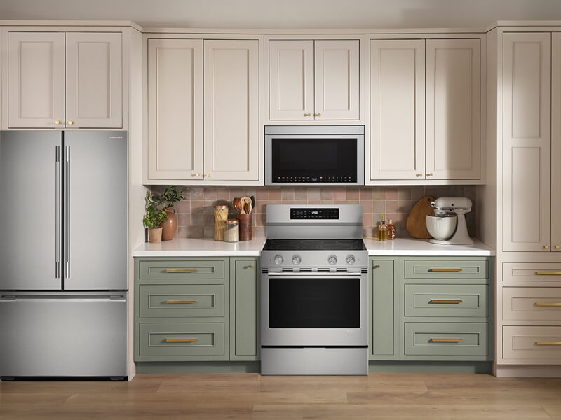 Stainless steel appliances in a white and green kitchen