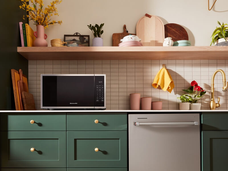 Countertop microwave and top control dishwasher in a green kitchen