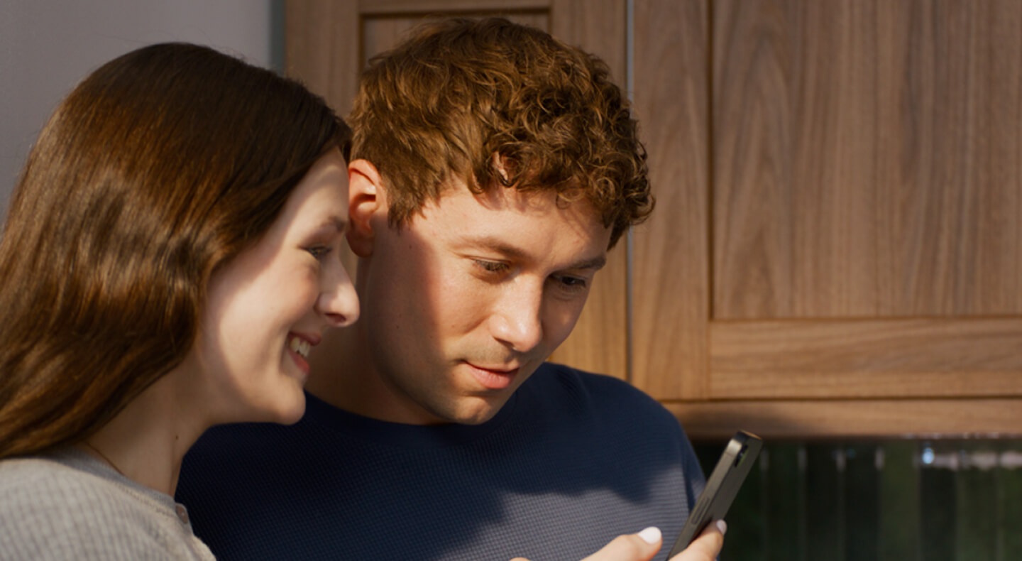Two people looking at a smartphone