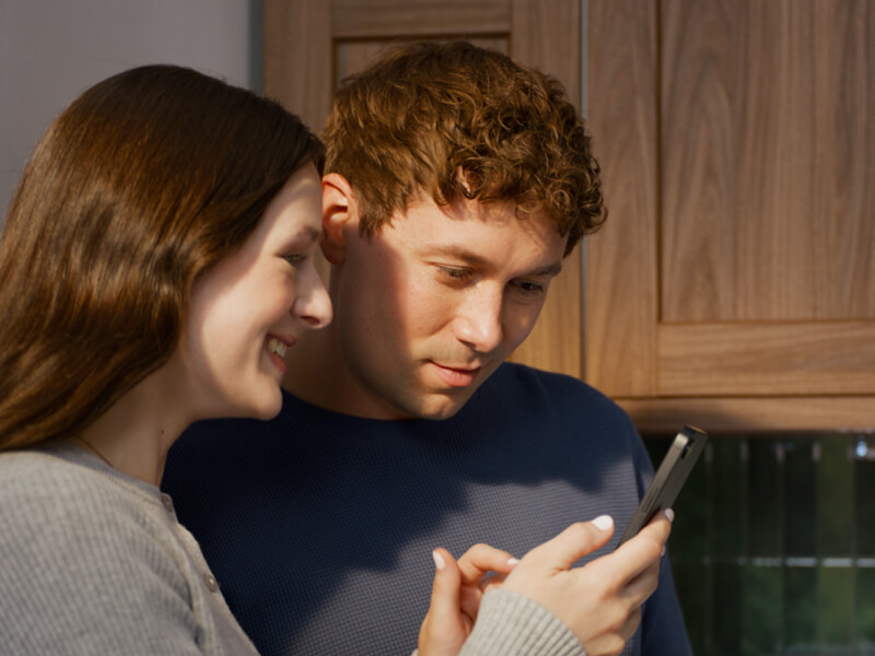 Two people looking at a smartphone