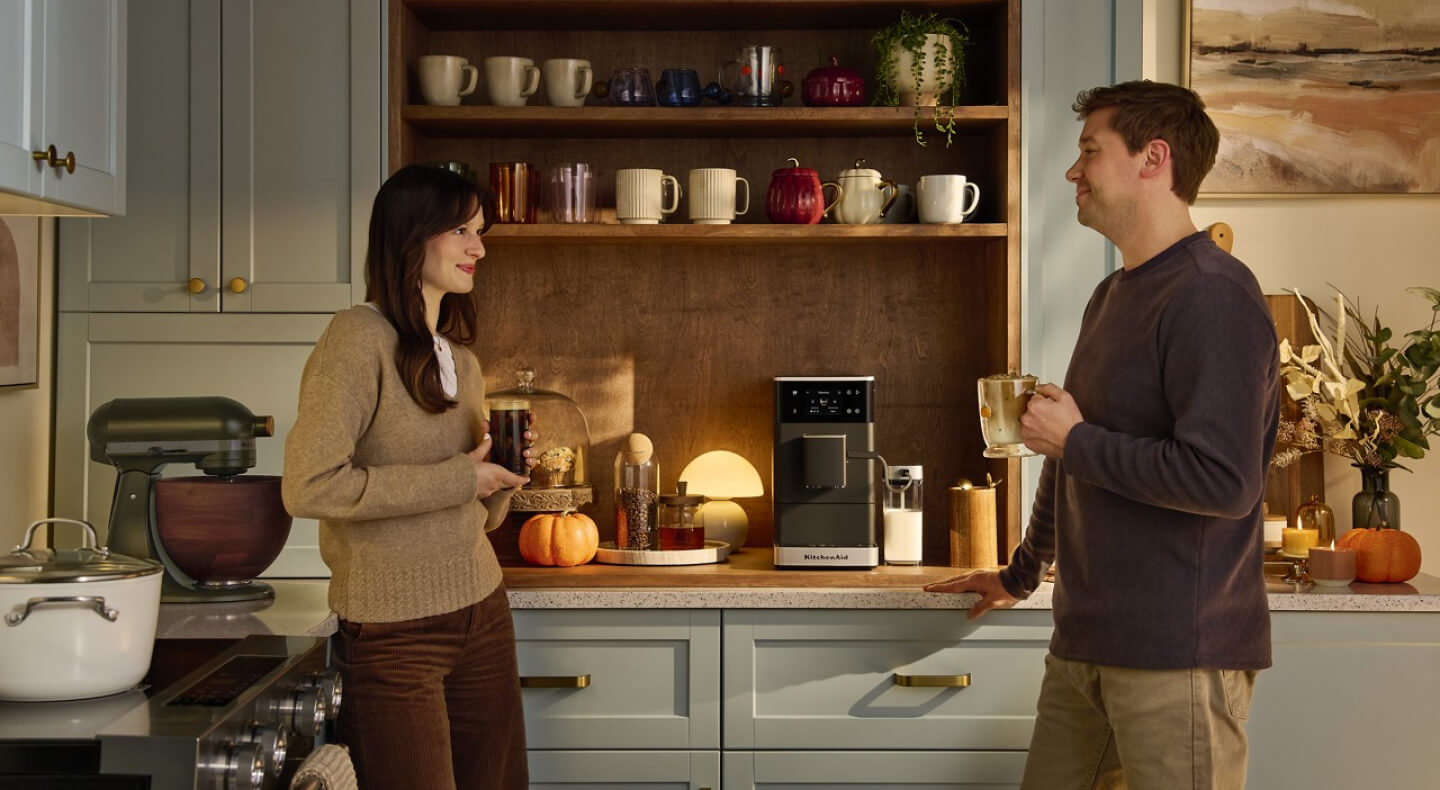 Two people drinking coffee in a modern, updated kitchen