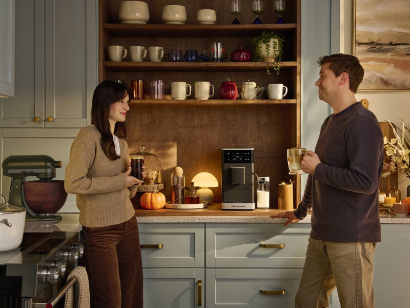 Two people drinking coffee in a modern, updated kitchen