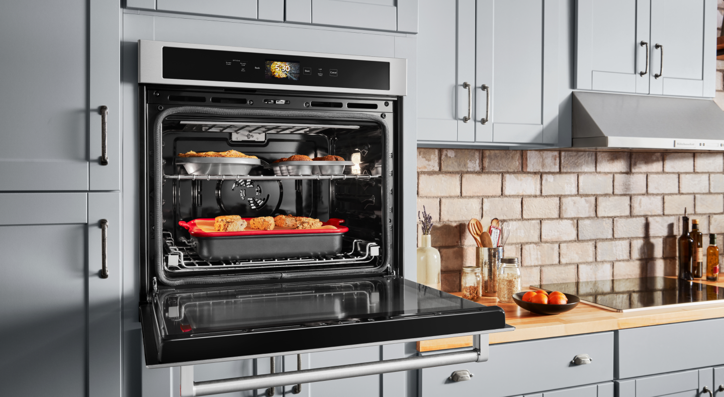  Open, single wall oven with food cooking on the top and bottom racks