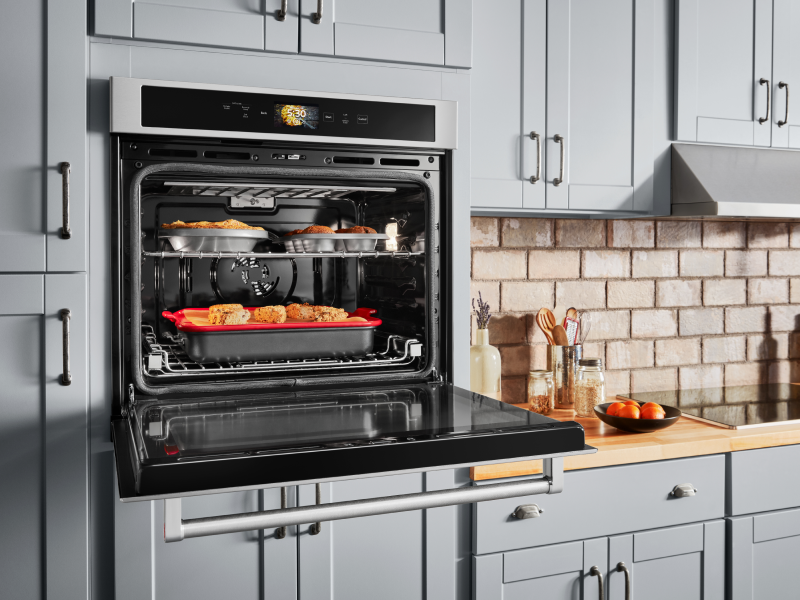  Open, single wall oven with food cooking on the top and bottom racks