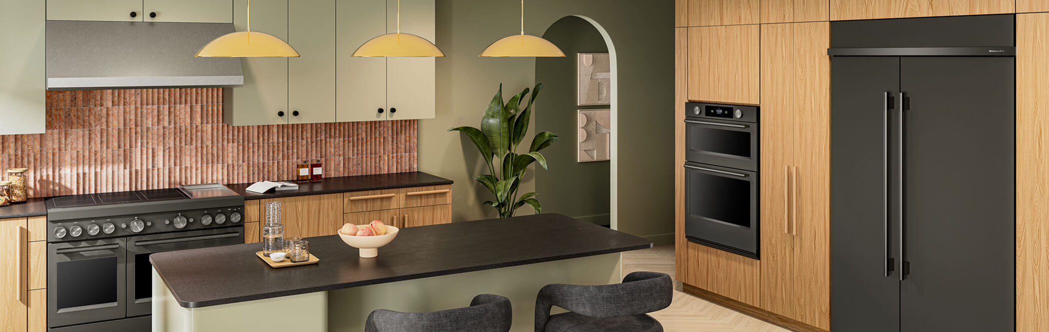 Built-in KitchenAid® refrigerator and wall oven in light wood cabinetry of open kitchen