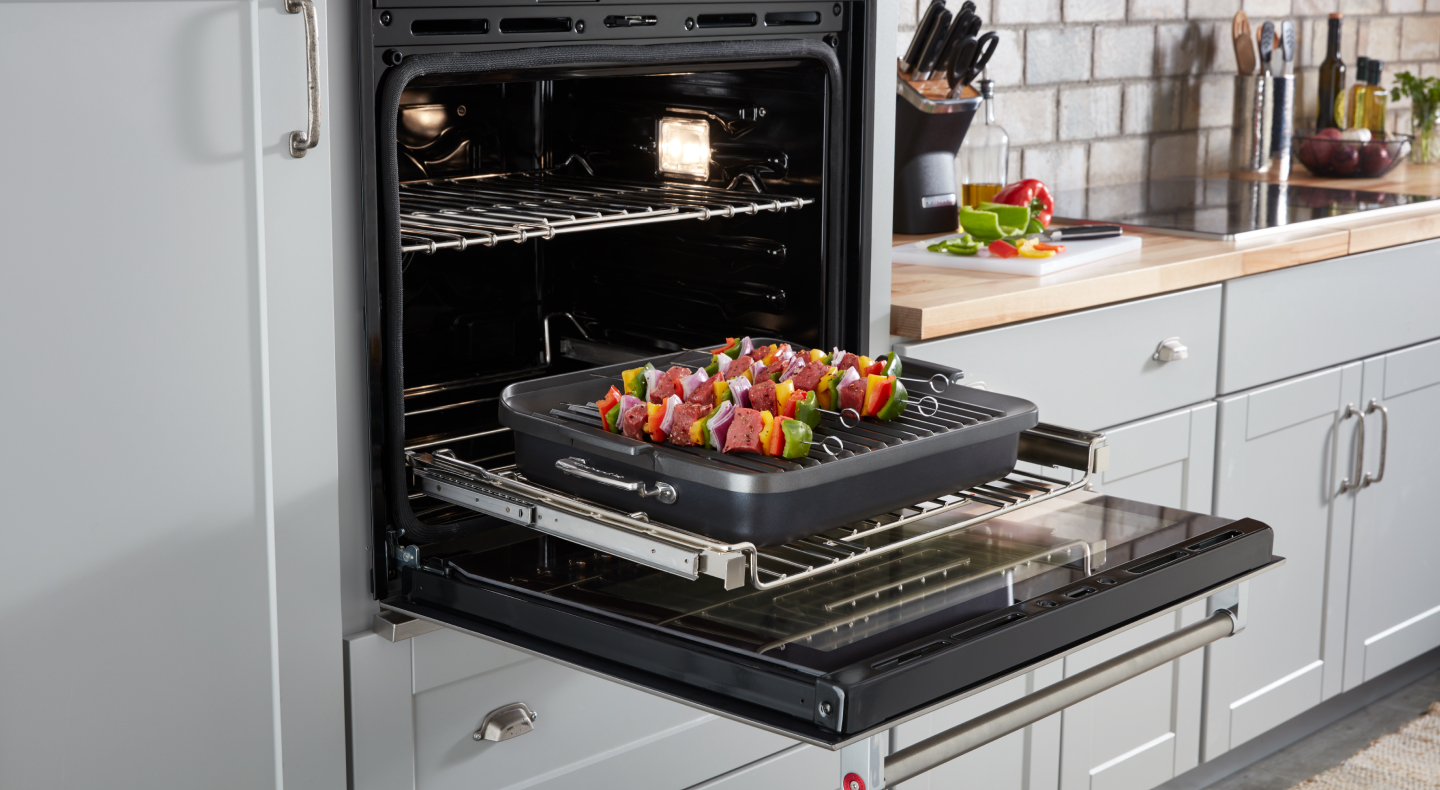 An open wall oven with freshly baked kebabs inside