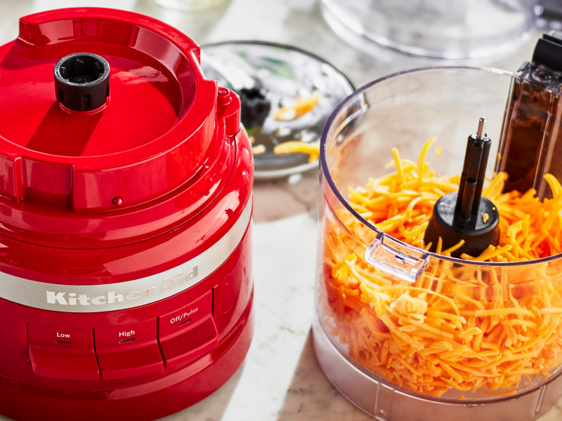 Red KitchenAid® food processor with shredded cheese in it