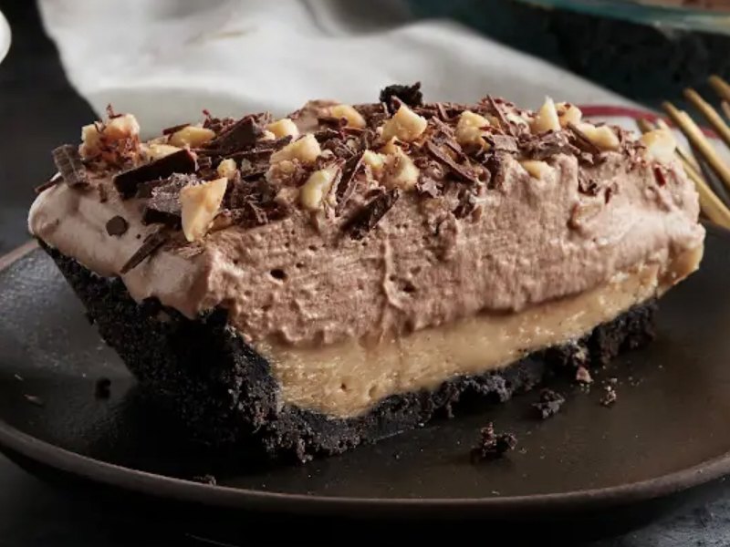 A homemade chocolate cake with nuts and chocolate shavings on top