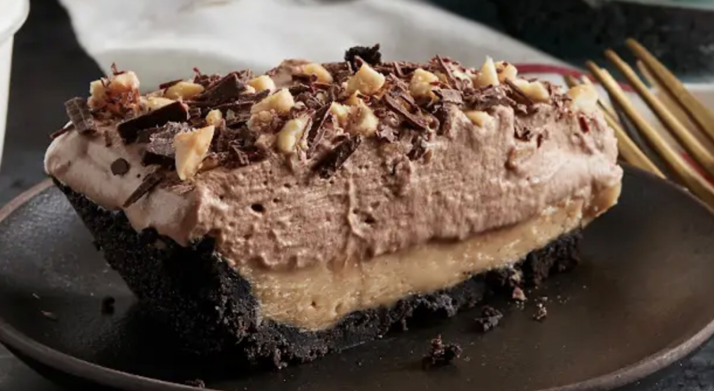 A homemade chocolate cake with nuts and chocolate shavings on top