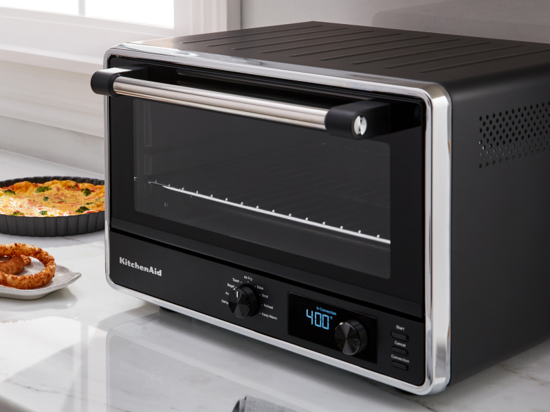 KitchenAid® countertop oven with onion rings on a tray