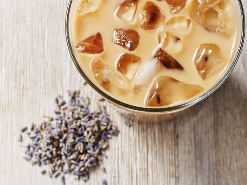  Iced coffee drink with fresh lavender buds on countertop