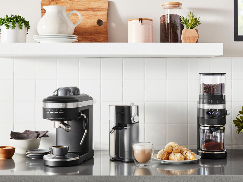 Coffee-making appliances from KitchenAid brand on counter with scones