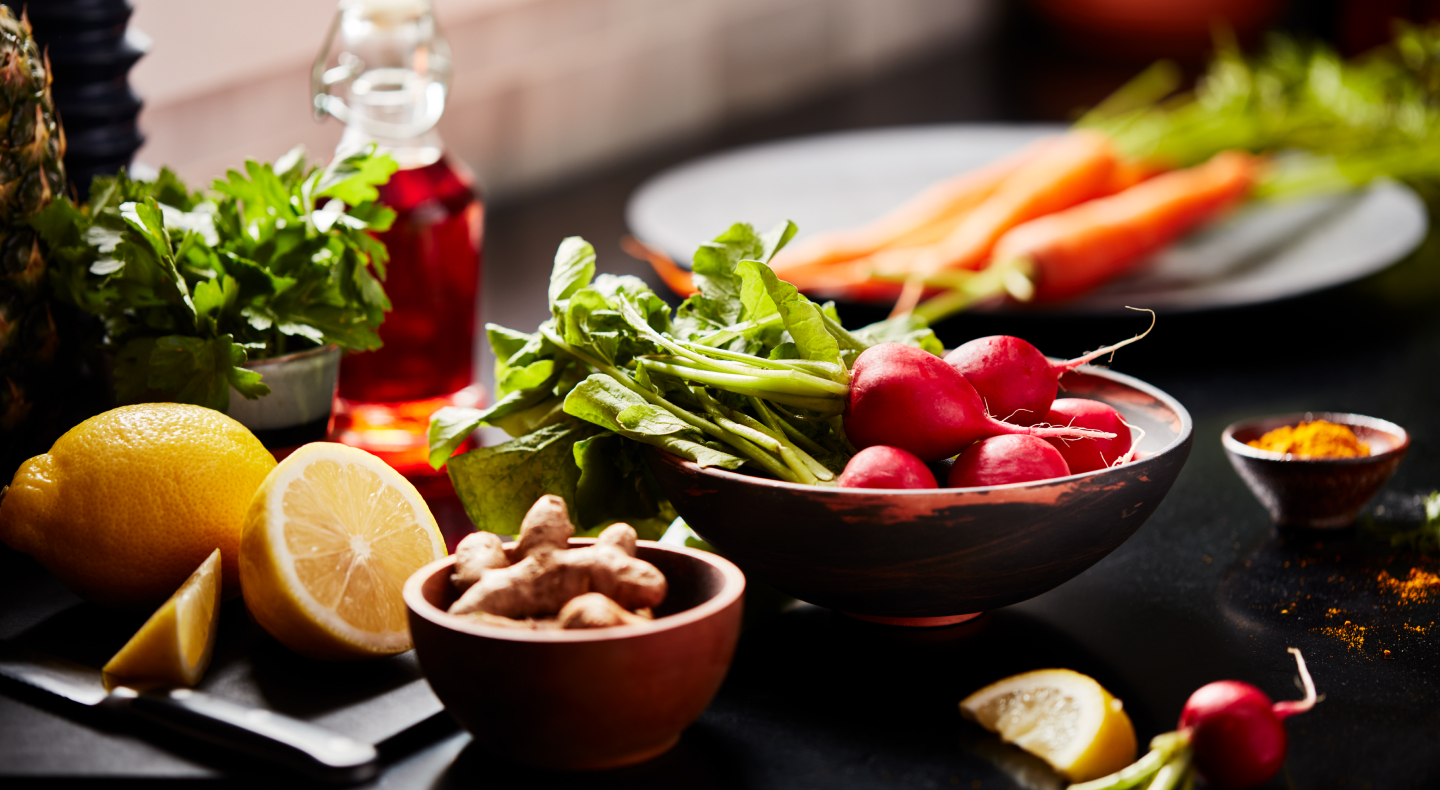 Lemons, carrots, radishes and lettuce on a countertop.