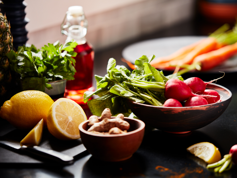 Lemons, carrots, radishes and lettuce on a countertop.