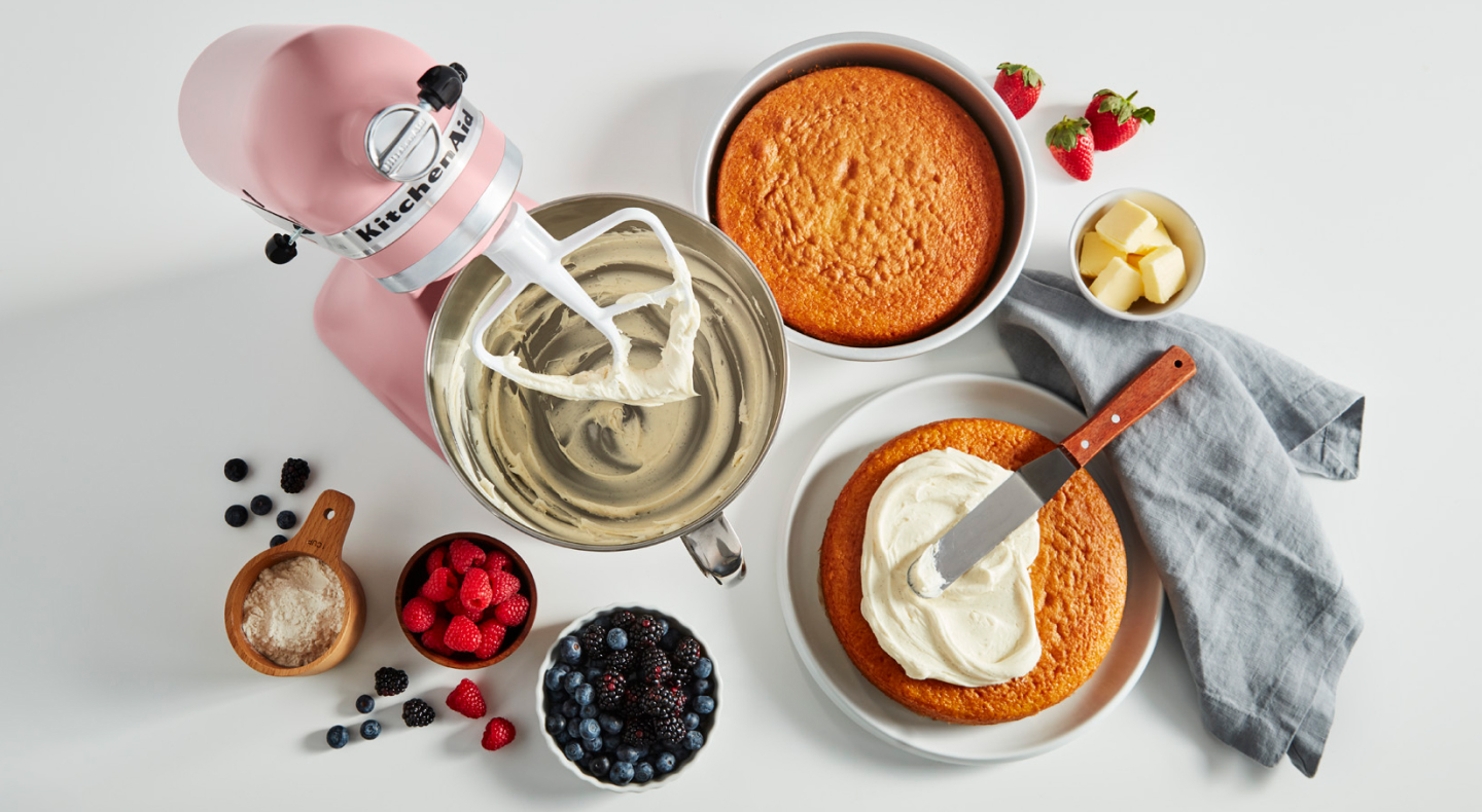 Stand mixer, cake layers and ingredients on a counter