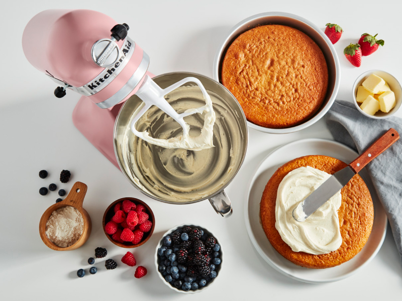 Stand mixer, cake layers and ingredients on a counter